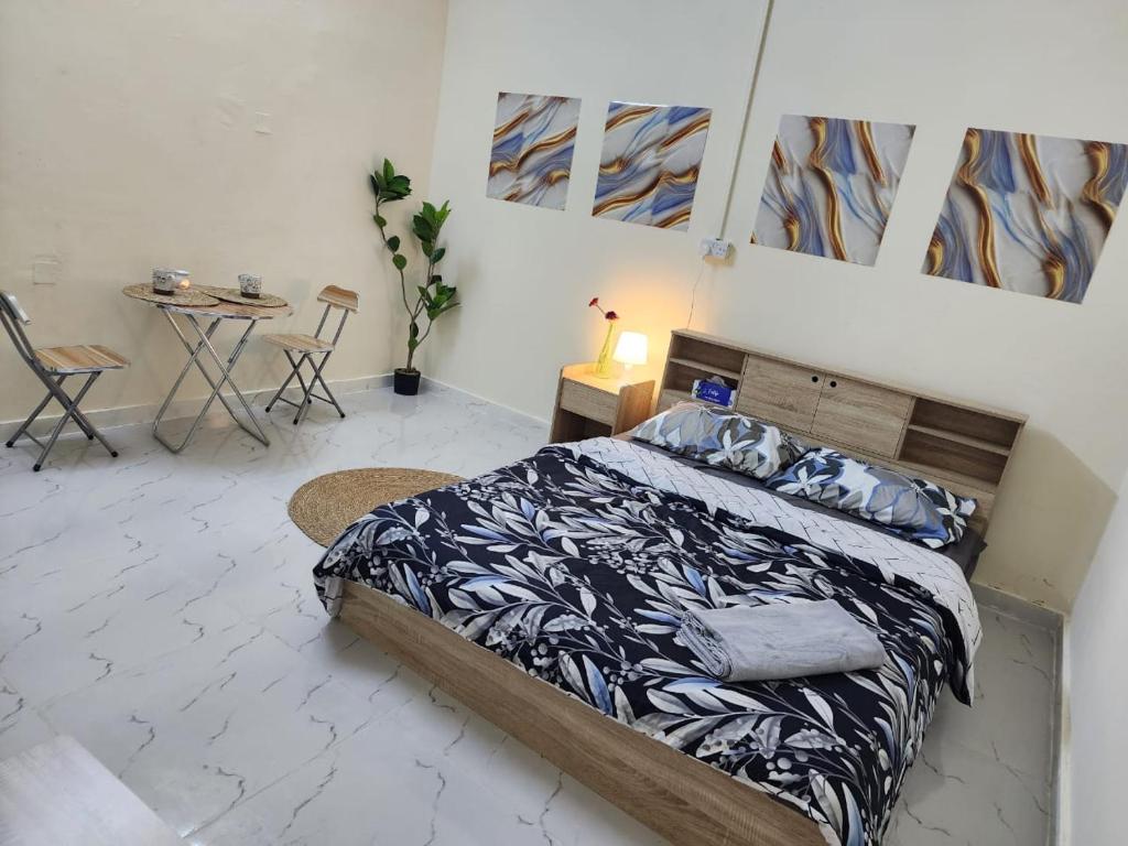 a bedroom with a bed and a table and chairs at Furnished hone stay villa with attached bathroom with balcony in Al 'Ayn