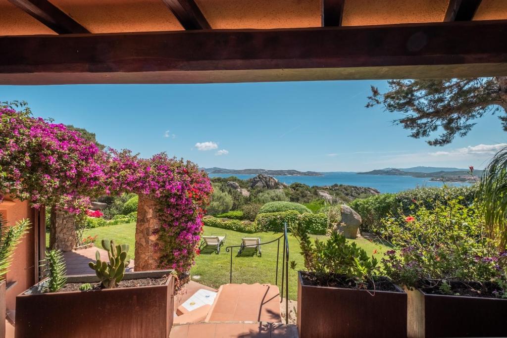 a view from the balcony of a house with flowers at Villa Ikigai, luxury, sea view swimming pool in Porto Rafael