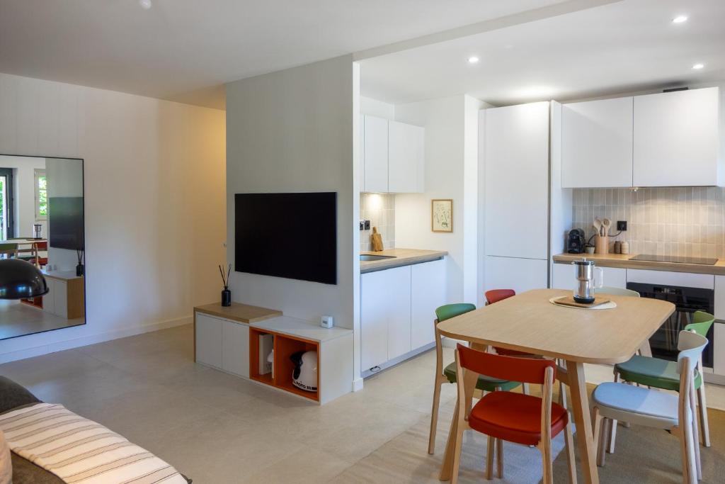 オルレアンにあるLe Mosaïc - Appartement Design - 2 chambres avec parking privé à Orléans hyper centreのキッチン、リビングルーム(テーブル、テレビ付)