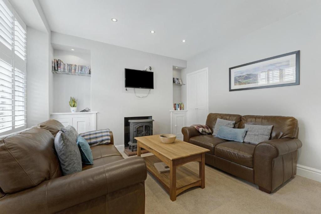 a living room with two couches and a tv at Roseberry Cottage in Ambleside