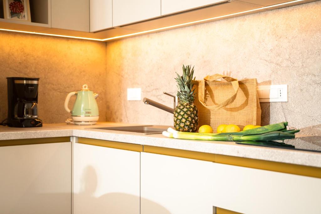 a kitchen with a counter with a pineapple and vegetables at VSG Resort - Relaxing Apartments, 200m from the Sea, with Pool, Sauna & Jacuzzi in Klimno