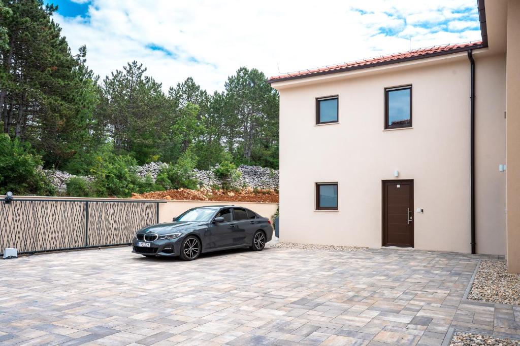 a car parked in a driveway in front of a house at VSG Resort - Relaxing Apartments, 200m from the Sea, with Pool, Sauna & Jacuzzi in Klimno