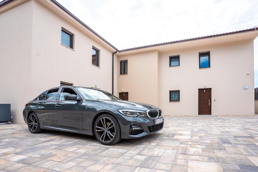 a black car parked in front of a building at VSG Resort - Relaxing Apartments, 200m from the Sea, with Pool, Sauna & Jacuzzi in Klimno