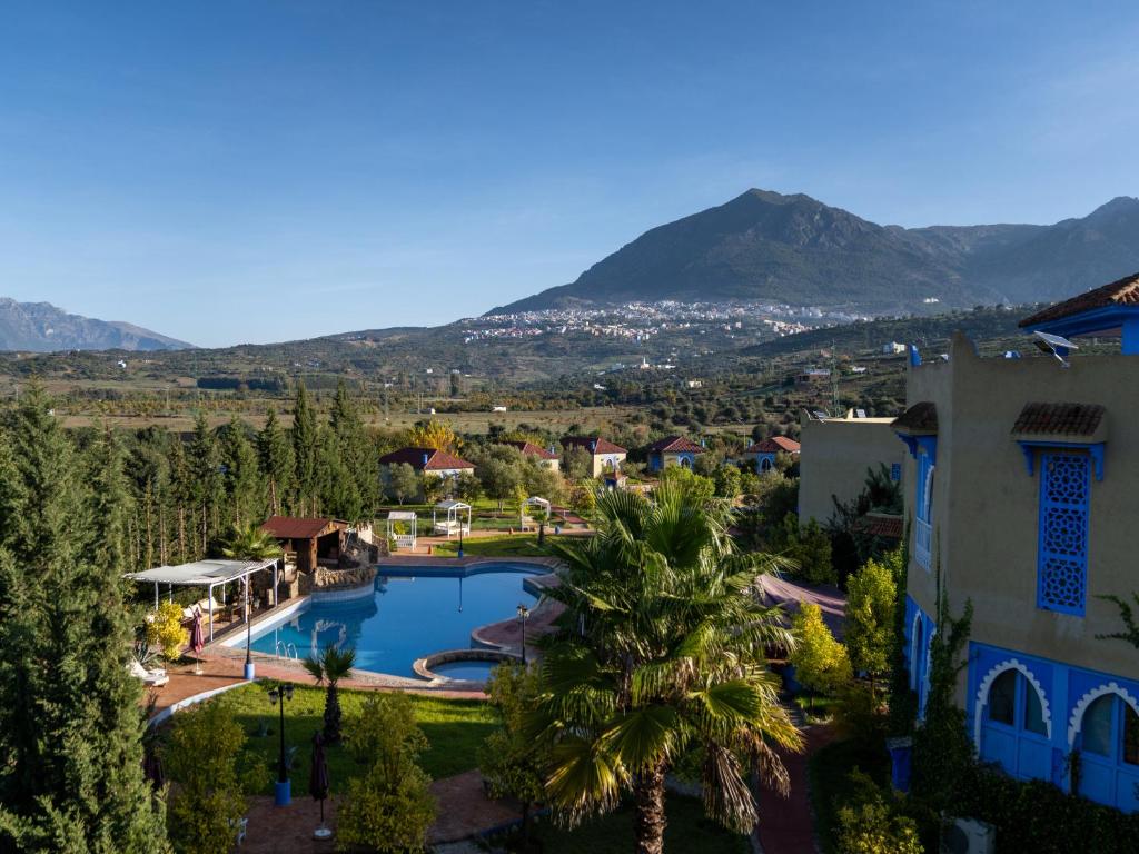an aerial view of a resort with a pool and mountains at Dar Ba Sidi & Spa Chefchaouen in Chefchaouen