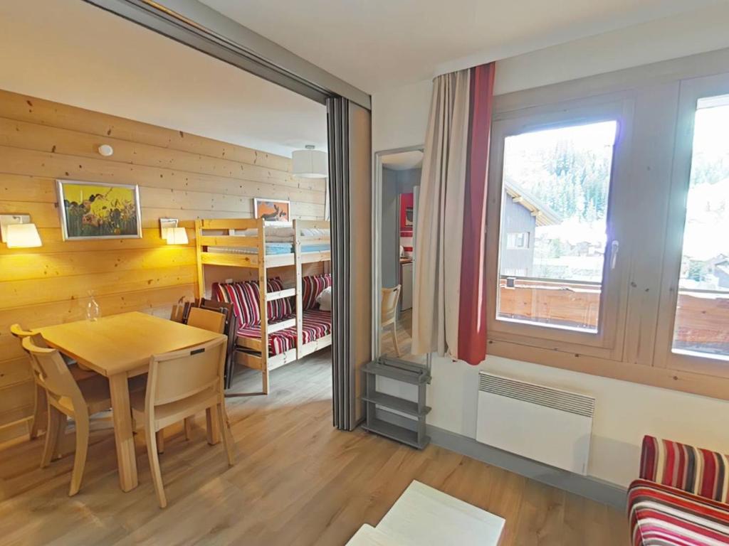 une salle à manger avec une table et des chaises et une fenêtre dans l'établissement Appartement cosy à La Plagne avec balcon ensoleillé et parking couvert - FR-1-351-250, à La Plagne Tarentaise