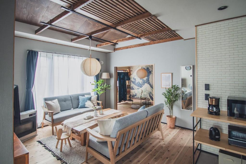 a living room with a couch and a table at 最大7名 海辺の一棟貸Villa BBQコンロ貸出可 洞爺湖20分 北斎の家 in Date