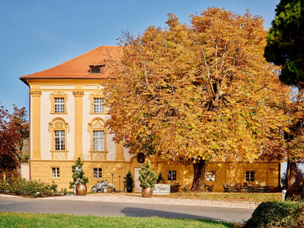 żółty dom z drzewem przed nim w obiekcie TAUROA Hofwirt w mieście Seckau