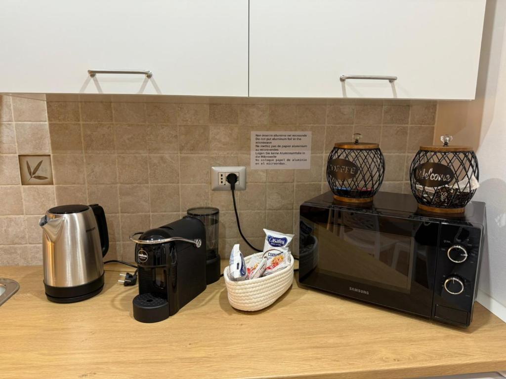 a kitchen counter with a microwave and two vases on top at La Maison di Annamaria in Bari