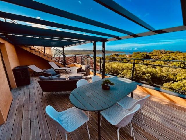 un patio avec une table et des chaises sur une terrasse dans l'établissement Luxueux T4 de 100m2 avec roof top, piscine et plage, à Pianottoli-Caldarello