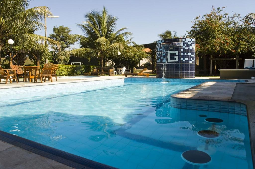 een groot zwembad met blauw water bij Hotel GAPH Maringa - Economico Mini Resort in Maringá