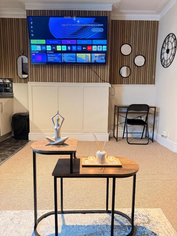 a room with a table and a tv on the wall at The Coral Stay by Station in Cambridge