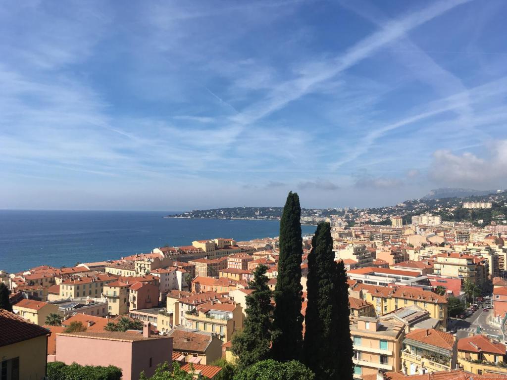 - une vue sur la ville avec ses arbres et l'océan dans l'établissement Chalet Marcel, à Menton