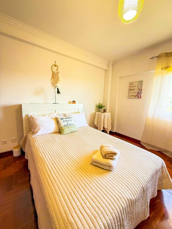 a bedroom with a large bed with two towels on it at Superhost Stay Garden View Double Room near Lisbon and Beaches in Corroios