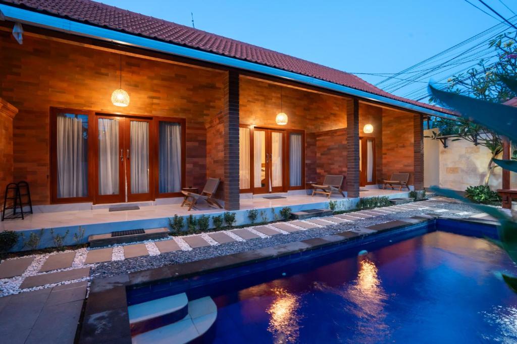 a house with a swimming pool in front of it at Nukulla House in Tumbak Bayuh