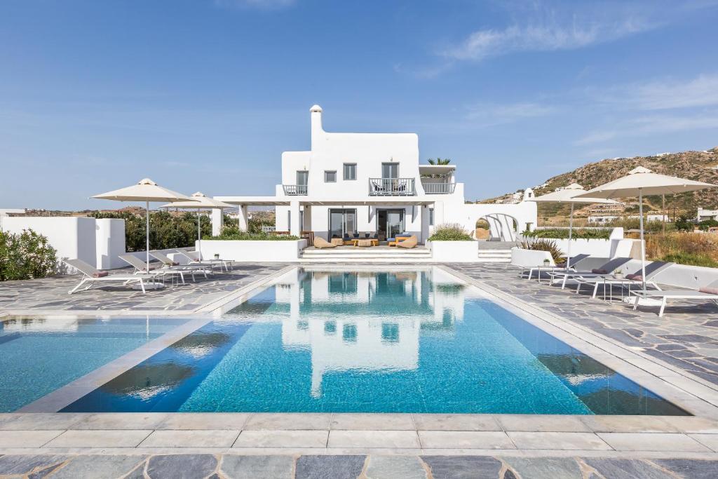 a villa with a swimming pool in front of a house at Ammilia Villa Naxos in Naxos Chora