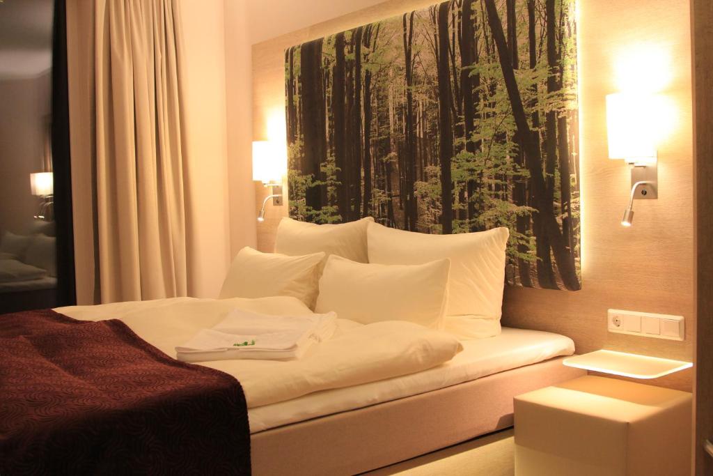 アンガーミュンデにあるFlair Hotel Weissのホテルルーム(壁に絵画が描かれたベッド付)