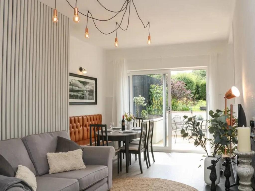 Una sala de estar con un sofá y una mesa con sillas. en Pass the Keys The Cabin Dog Friendly Haven with Hot Tub Sleeps 4, en Hayfield