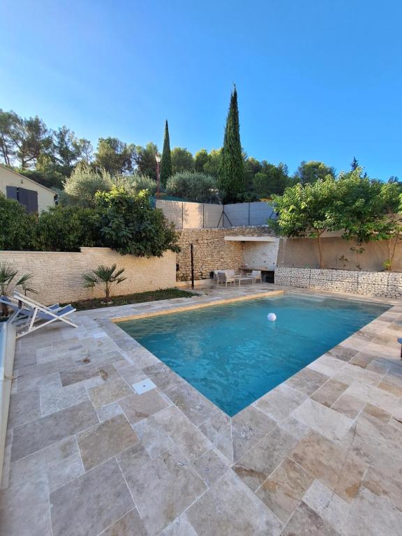 - une piscine dans une cour dotée d'un mur en pierre dans l'établissement Fontaine de bonheur, à Fontaine-de-Vaucluse