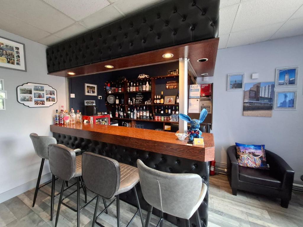 a bar in a restaurant with four chairs at Westbrook Lodge Guest House in Margate