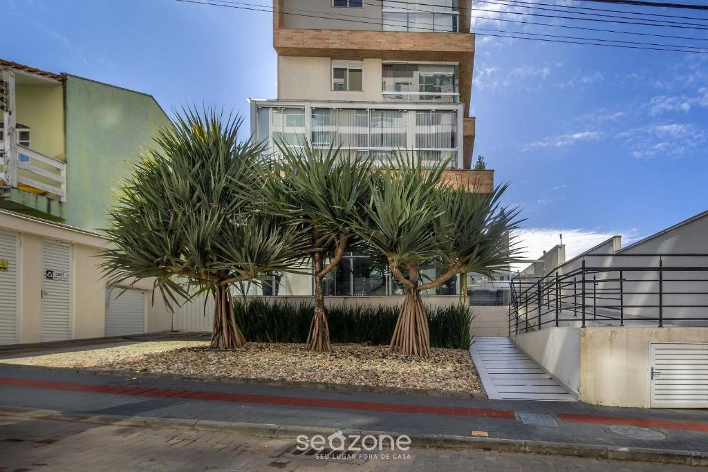 a row of palm trees in front of a building at Estadia sofisticada a 200m da Praia Brava - EHI in Praia Brava