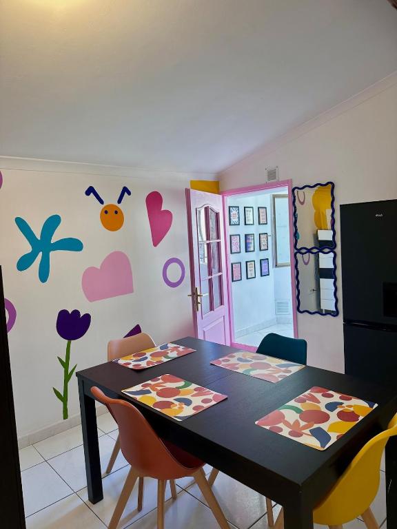 a dining room with a black table and chairs at POP HOUSE - Appartement coloré et fun en Camargue in Saint-Gilles