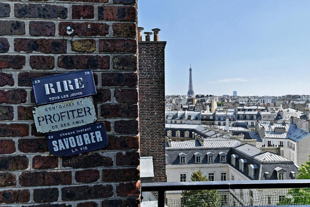 un panneau sur un mur de briques avec vue sur la tour Eiffel dans l'établissement Studio Terrasse vue incroyable sur Tour Eiffel, à Paris