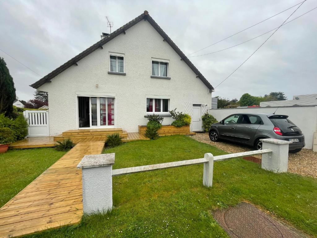 une maison blanche avec une voiture garée devant elle dans l'établissement Charmante maison 3 chambres, à Cucq