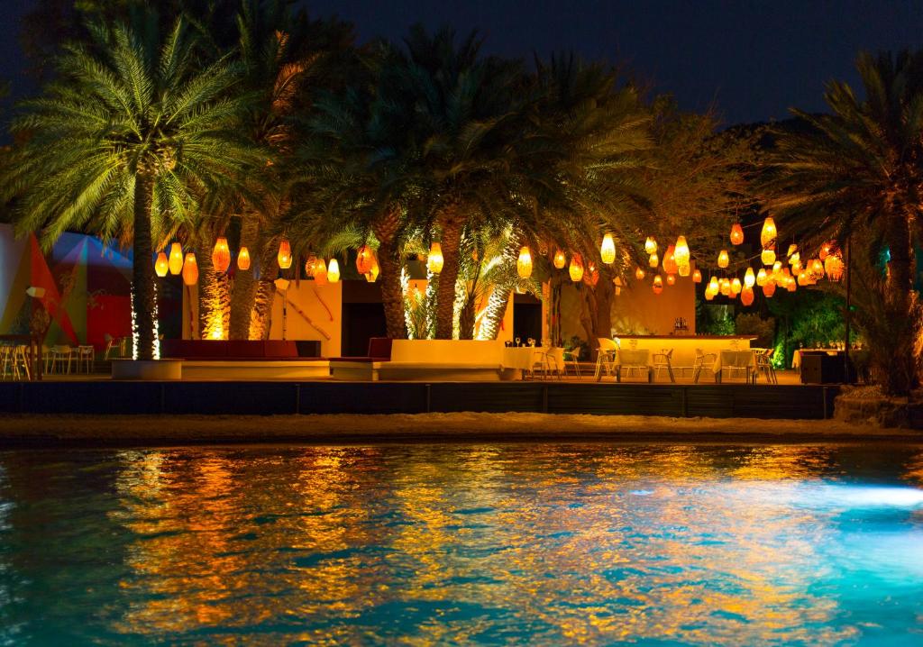a pool of water with palm trees and lights at The Marmara Bodrum - Adult Only in Bodrum City