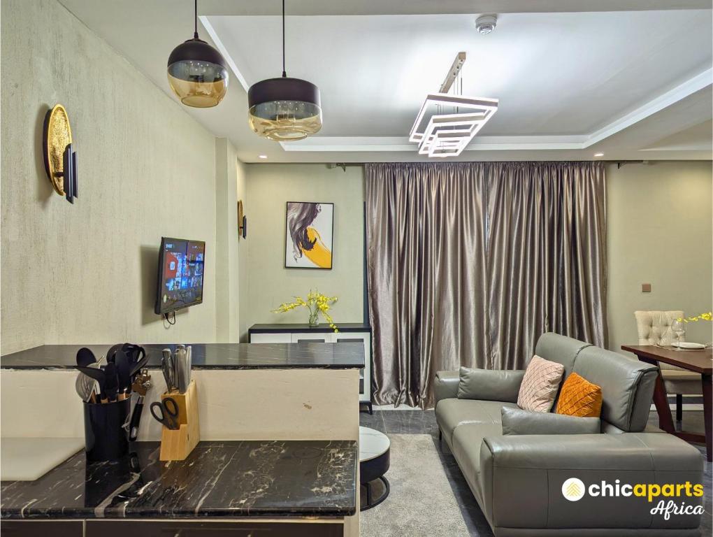 a living room with a couch and a tv at Studio chic avec parking près de l'aéroport in Douala