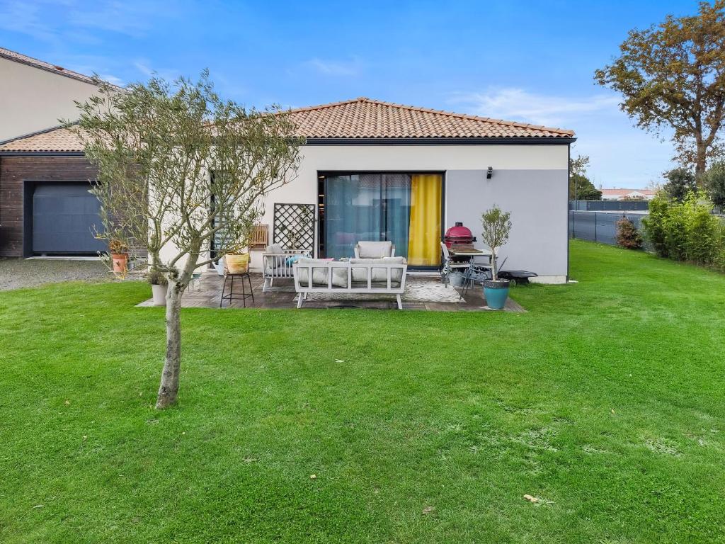 une maison avec une cour avec une table et des chaises dans l'établissement Maison de famille à 14min à pied de la mer, à Pornic