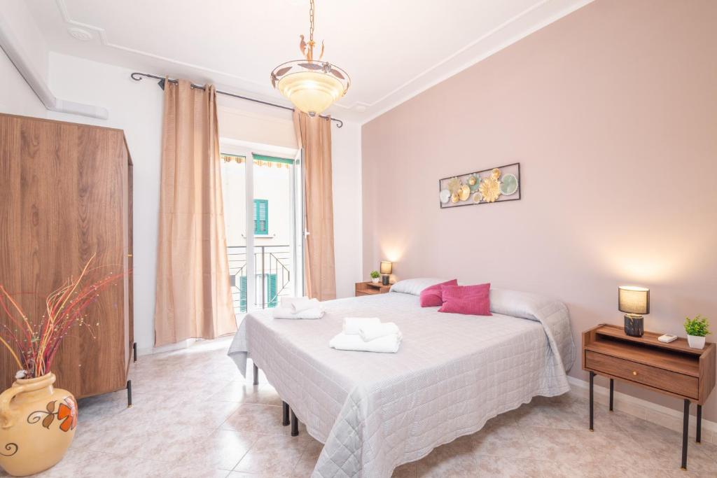 una camera da letto con un grande letto bianco con cuscini rossi di Piombino Apartments Casa Rossana a Piombino