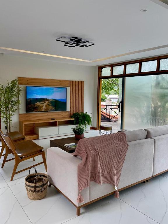a living room with a couch and a flat screen tv at Casa da Concordia in Vassouras