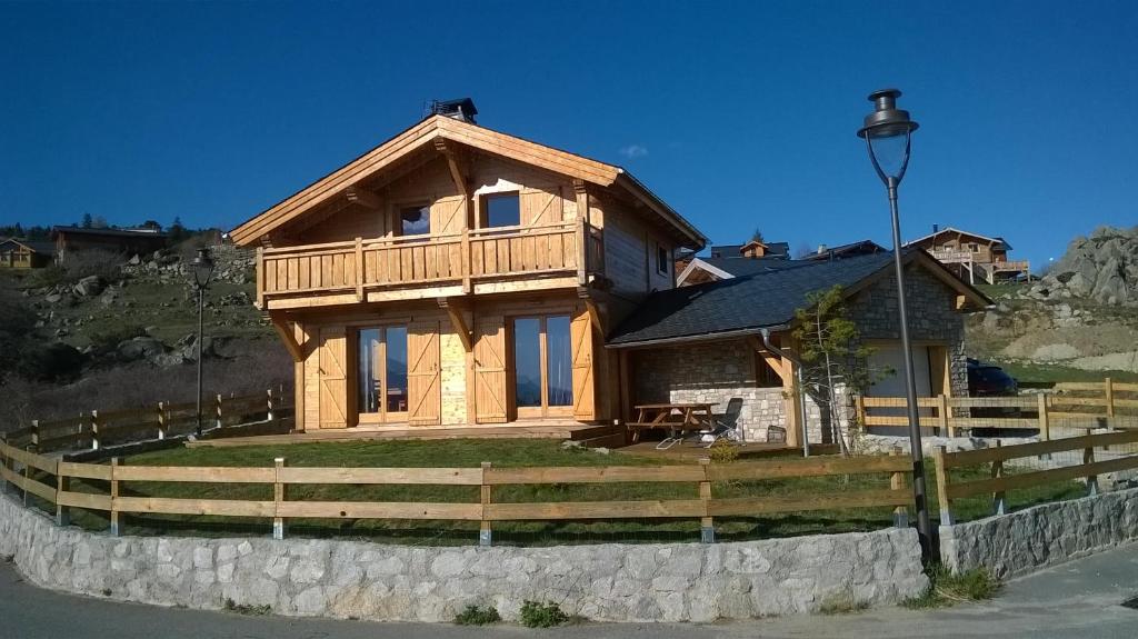 une maison en bois avec une clôture devant elle dans l'établissement Charmant chalet Maya classé 3 étoiles, à Font-Romeu