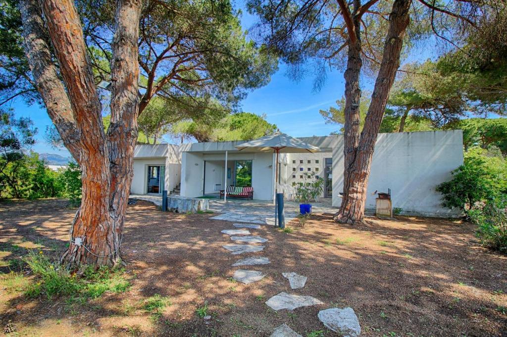 une maison blanche avec des arbres devant dans l'établissement Villa domaine de la pointe Porticcio, à Porticcio