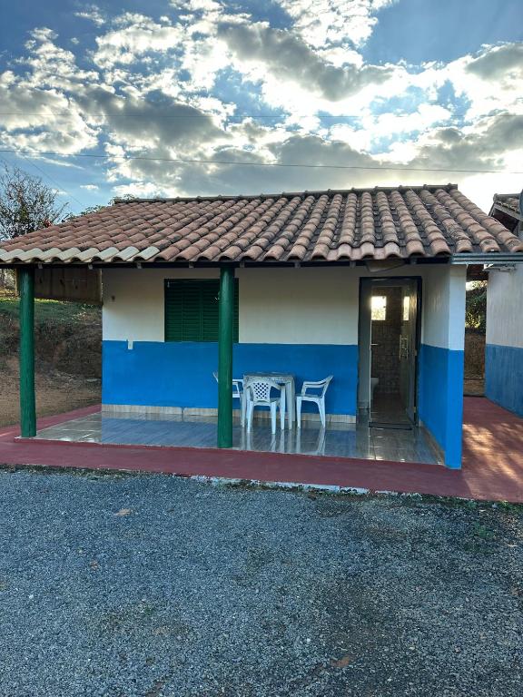 a blue and white house with a table and chairs at Chalés Relíquias da Canastra I in São Roque de Minas