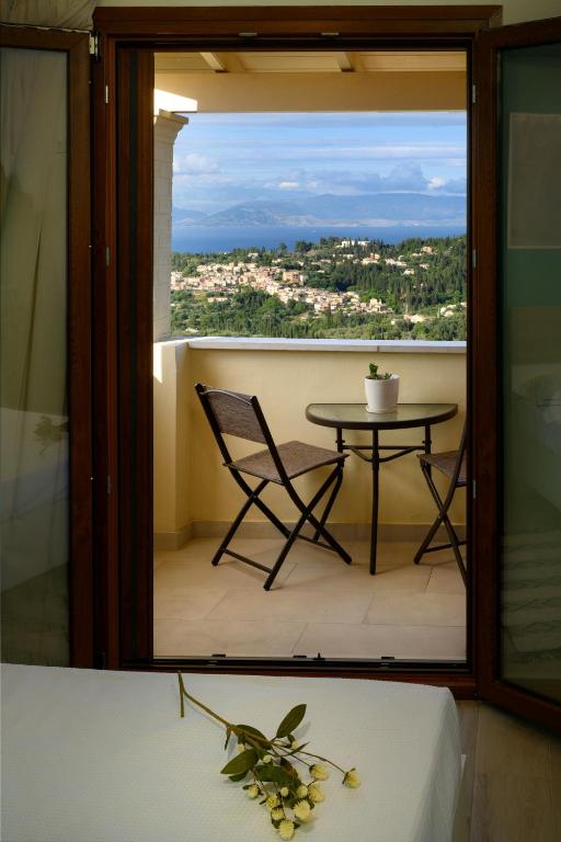 a room with a table and a chair on a balcony at Thea Divine Comfort & View in Áyioi Dhéka