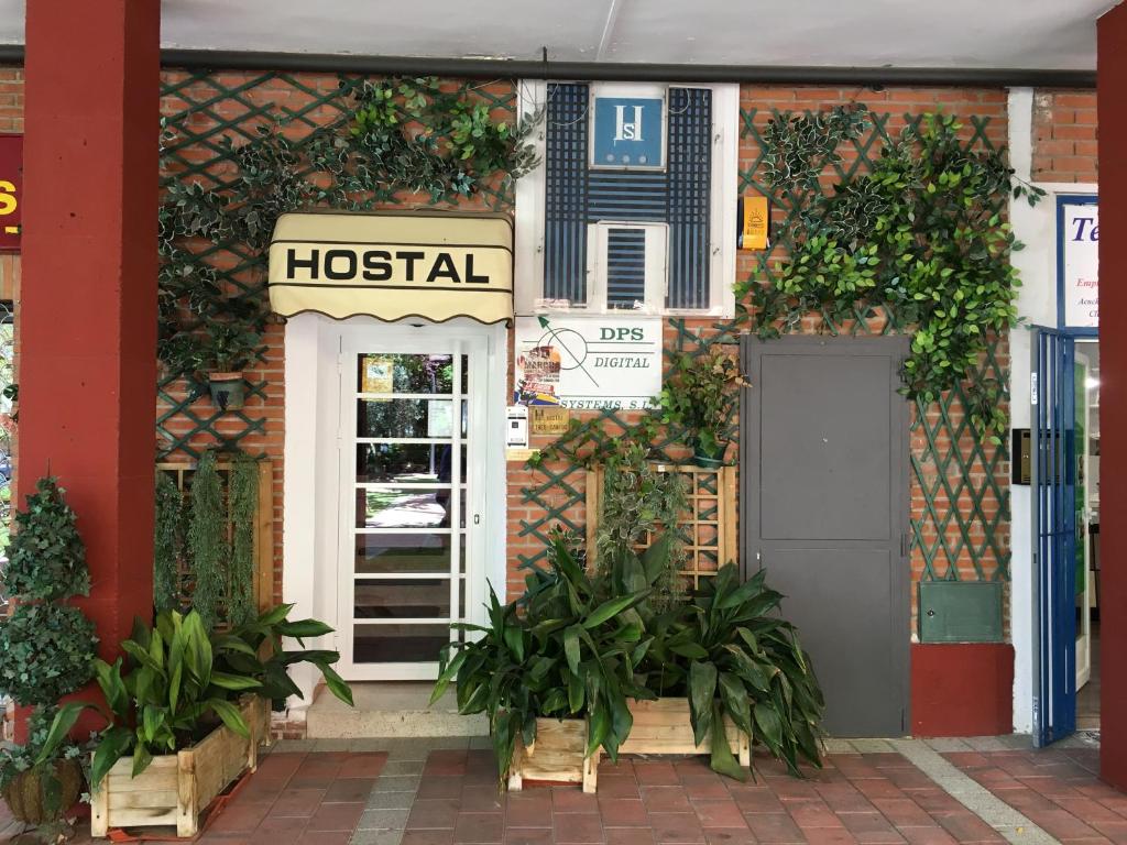 a building with a hospital sign and a door at Hostal Tres Cantos in Tres Cantos