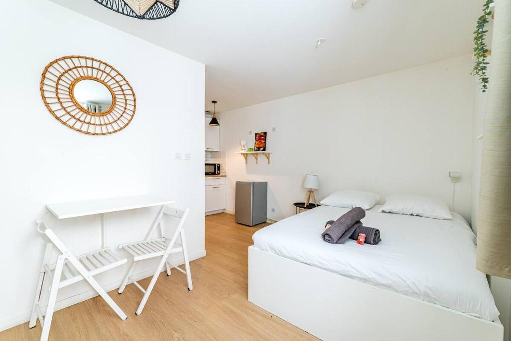 une chambre blanche avec un lit et un bureau dans l'établissement Studio au coeur du panier, à Marseille