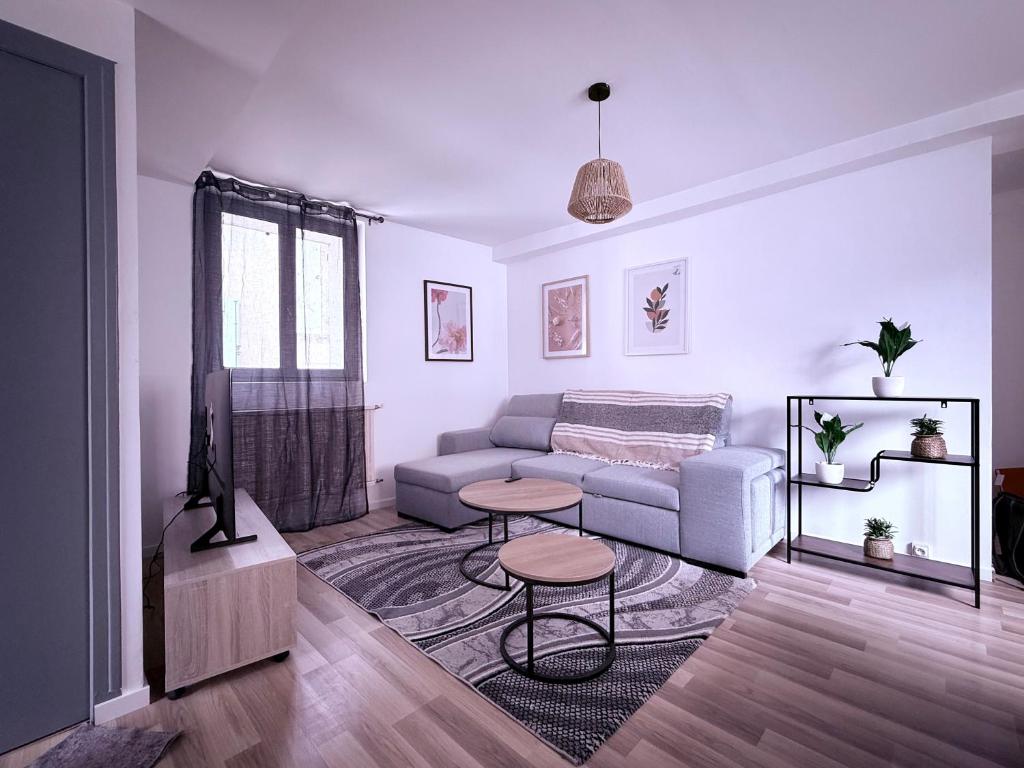 ein Wohnzimmer mit Sofa und Tisch in der Unterkunft Appartement centre historique Auxerre Arrivée autonome in Auxerre