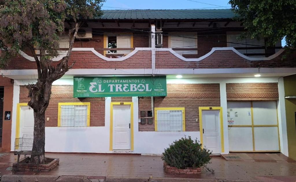 a building with a green sign in front of it at Departamentos por dia EL TREBOL in Paso de los Libres