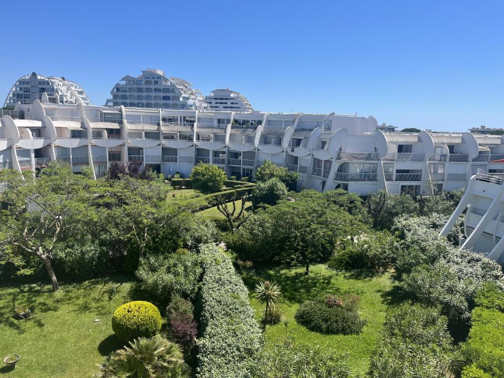 un immeuble d'appartements avec un jardin devant dans l'établissement Sol-y-Days Soleil du Couchant Appartement avec terrasse et parking, à La Grande Motte
