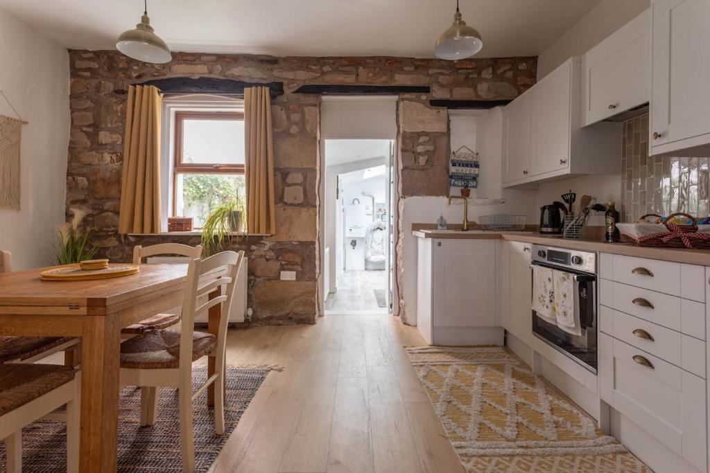a kitchen with a wooden table and a dining room at Fisherman's Cottage by the sea in Morecambe