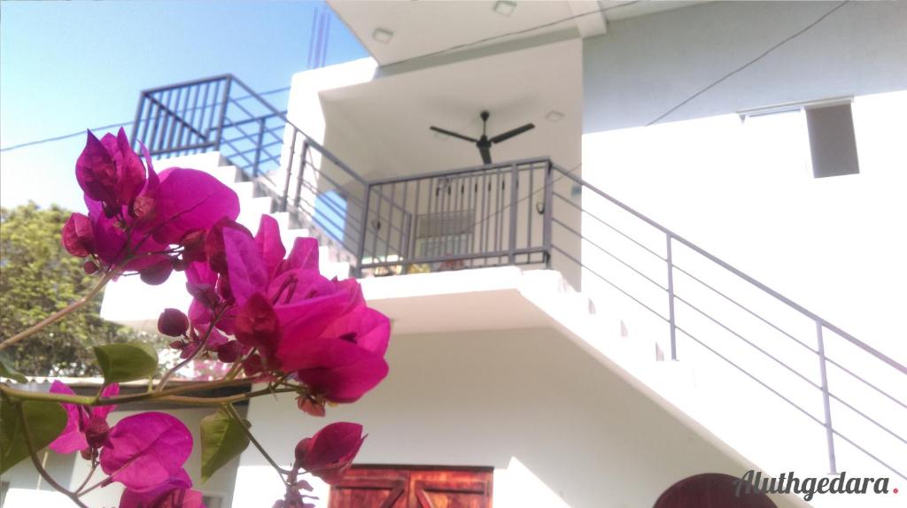 a stairway with pink flowers in front of a building at Aluthgedara Guest House in Unawatuna