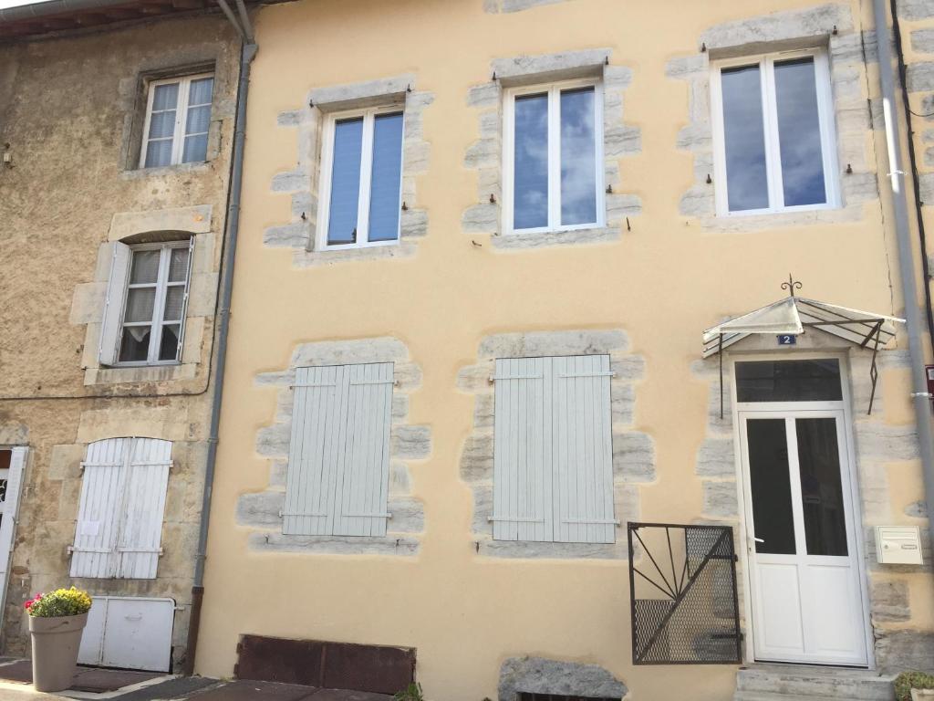 une vieille maison avec des fenêtres et un parapluie sur la façade dans l'établissement giteMANU, à Arbois