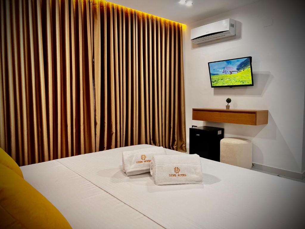 a hotel room with a bed with two towels on it at Dine Hotel in Ksamil