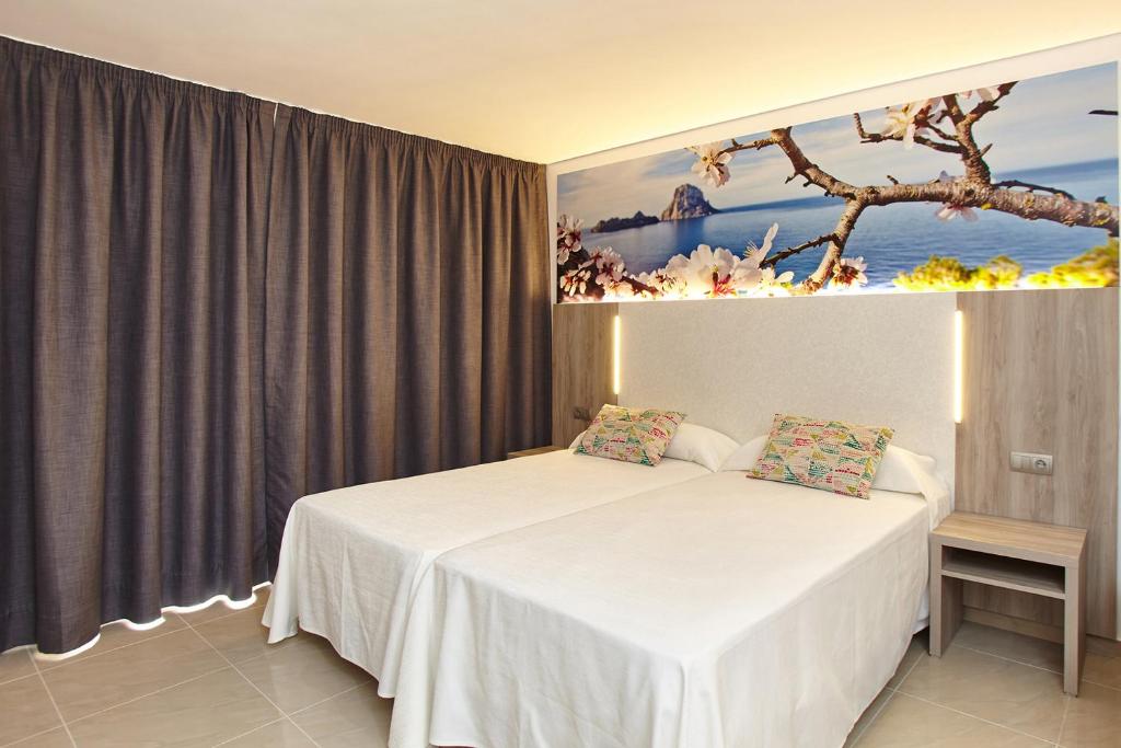 sypialnia z łóżkiem i obrazem na ścianie w obiekcie Apartamentos Mar i Vent w mieście San Antonio
