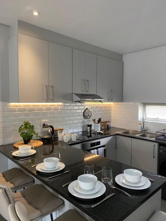 a kitchen with white cabinets and a black counter top at Boerbok & Bloom in Paarl