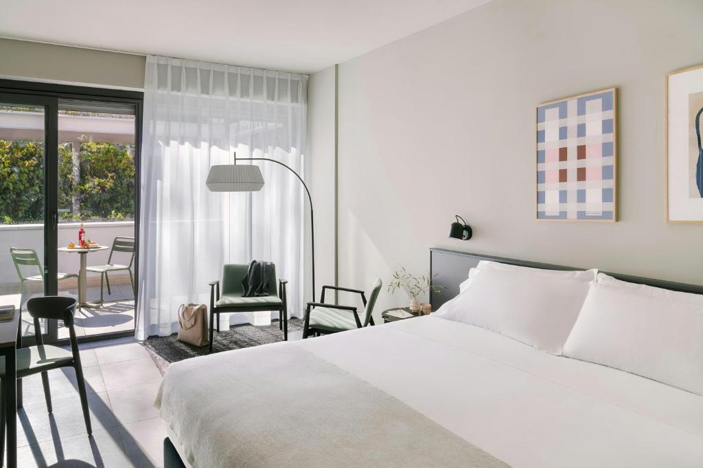 a bedroom with a bed and a balcony with a table at Testaccio Hotel Monte dei Cocci, Sonder by Marriott Bonvoy in Rome