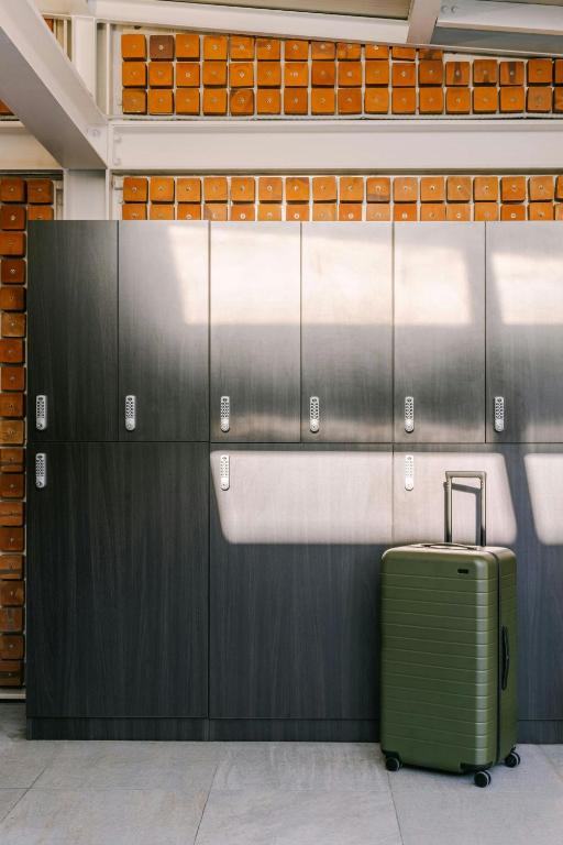 a suitcase is sitting next to a wall in an airport at Testaccio Hotel Monte dei Cocci, Sonder by Marriott Bonvoy in Rome