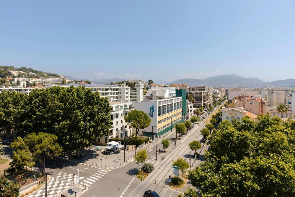 a street in a city with trees and buildings at Yelo Promenade Hotel Magnan, Sonder by Marriott Bonvoy in Nice